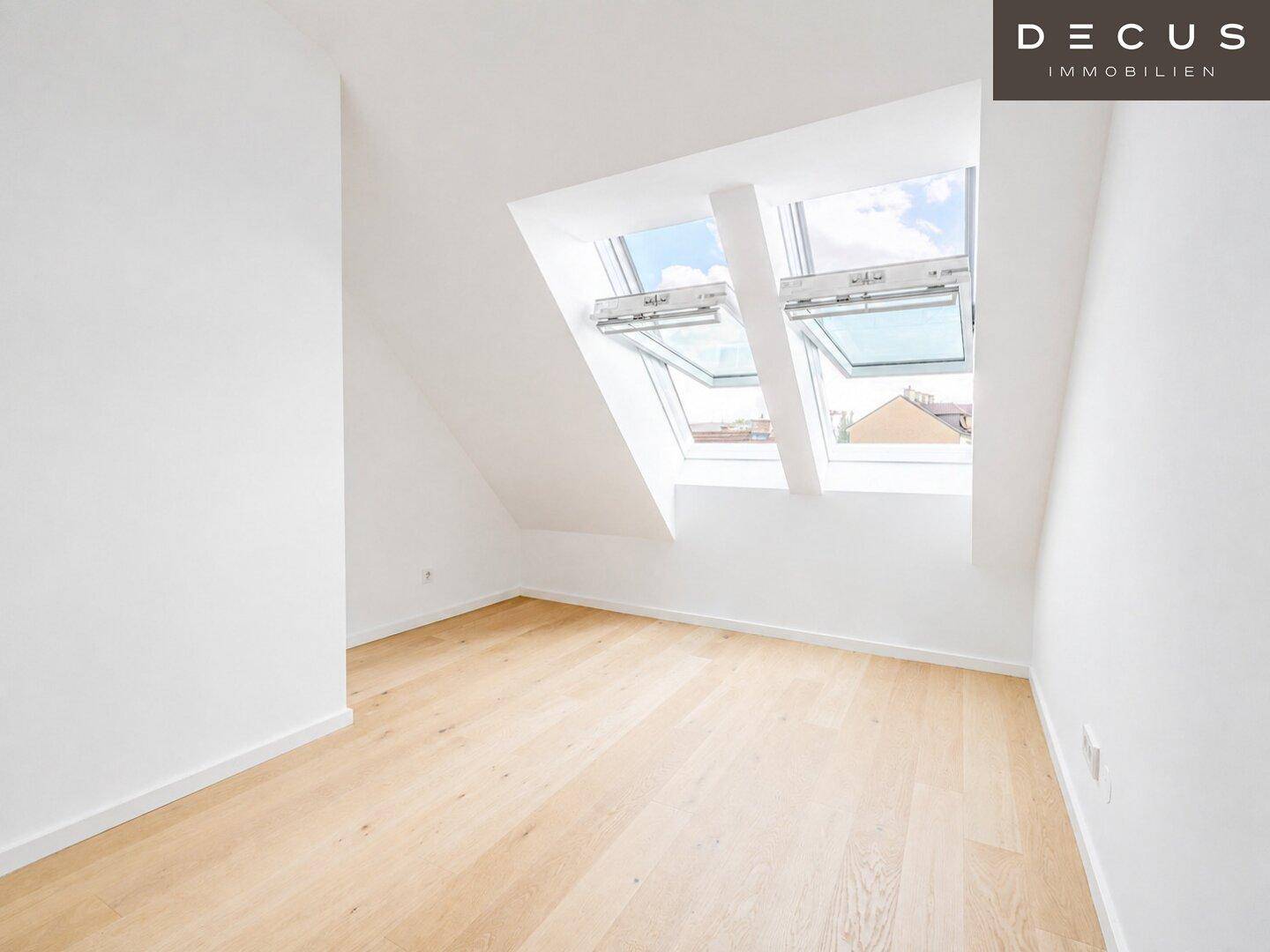 Geräumiges, helles Zimmer mit Holzboden und zwei Dachfenstern, die viel Tageslicht spenden.
