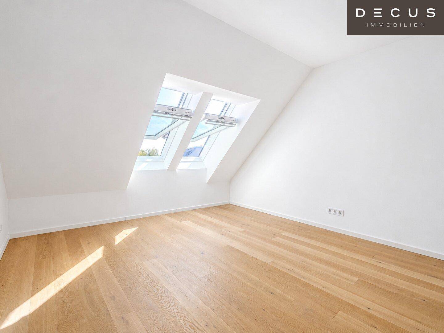 Helles Zimmer mit Holzboden, Dachschräge und Dachfenstern, die für eine angenehme Atmosphäre sorgen.