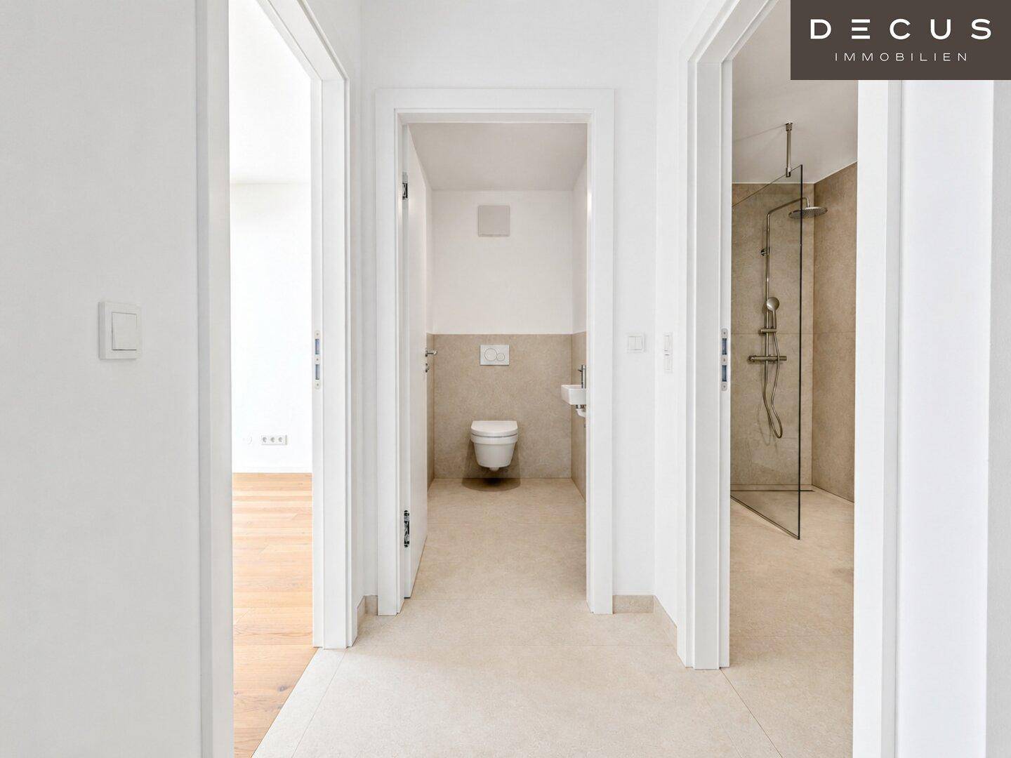 Flur mit Fliesenboden und Zugängen zu einem Gäste-WC und einem modernen Badezimmer.