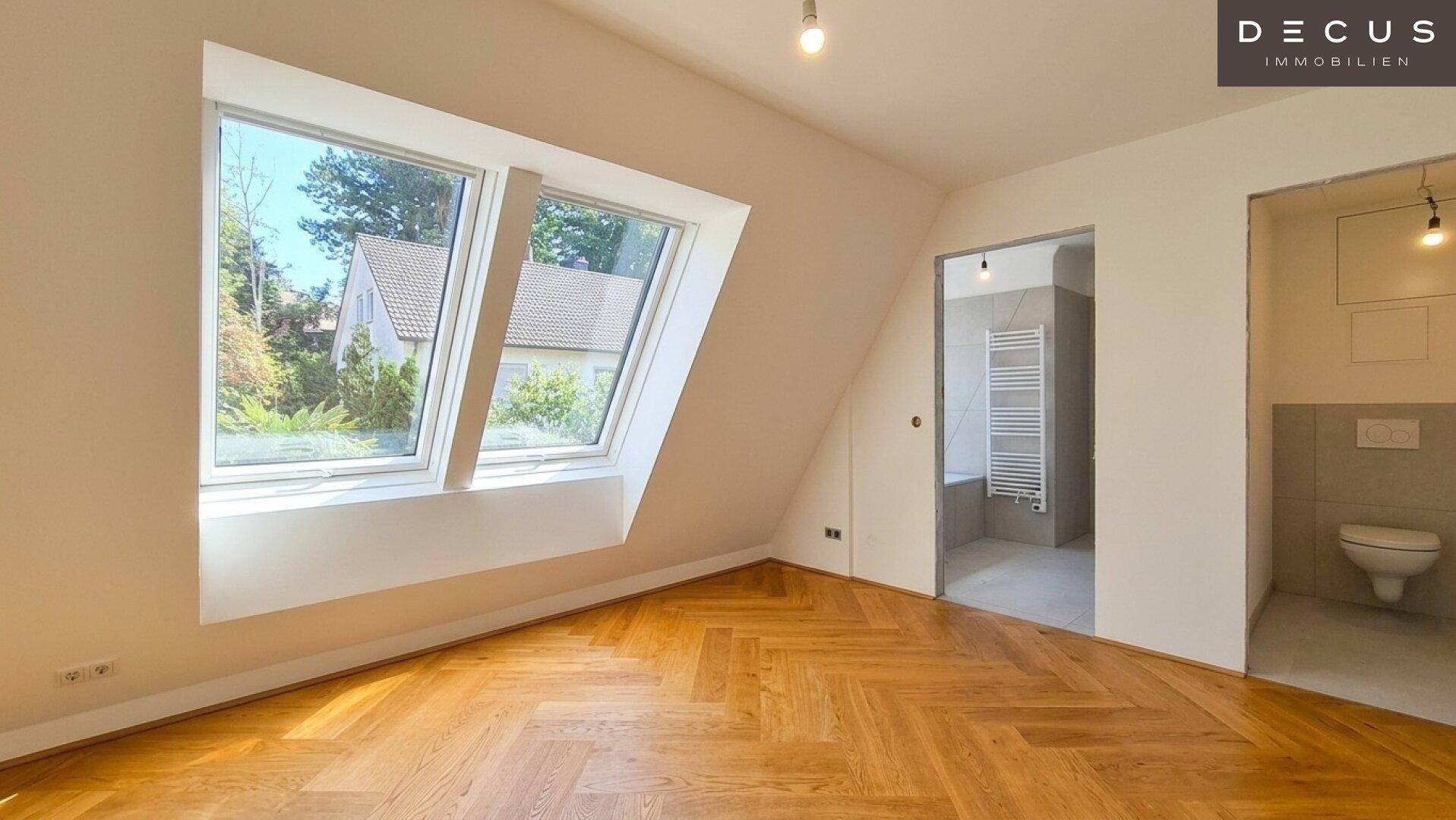 Helles Schlafzimmer mit Fischgrätparkett, Dachfenstern und direktem Zugang zum Badezimmer.