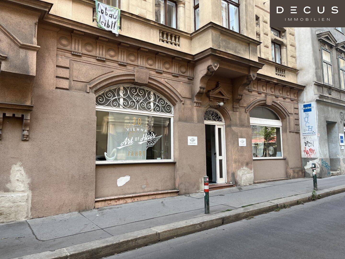 Historische Fassade eines Altbaus an einer städtischen Straße mit dekorativen Elementen.