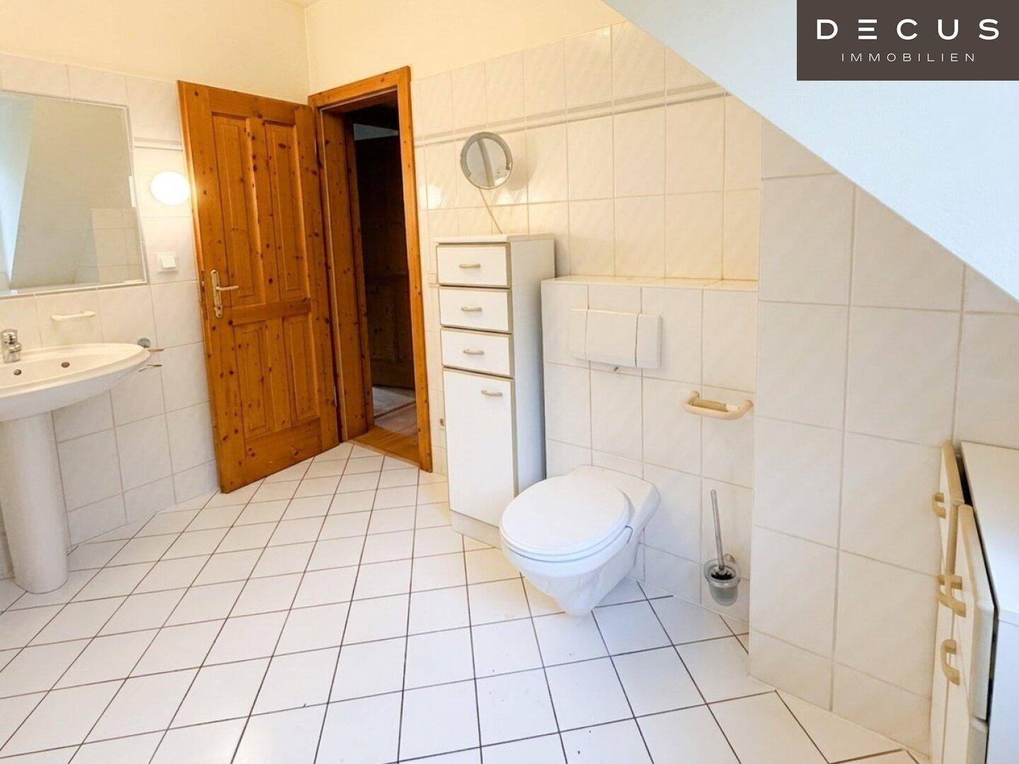 Modernisiertes Badezimmer im Dachgeschoss mit WC, Waschtisch und Spiegelschrank.