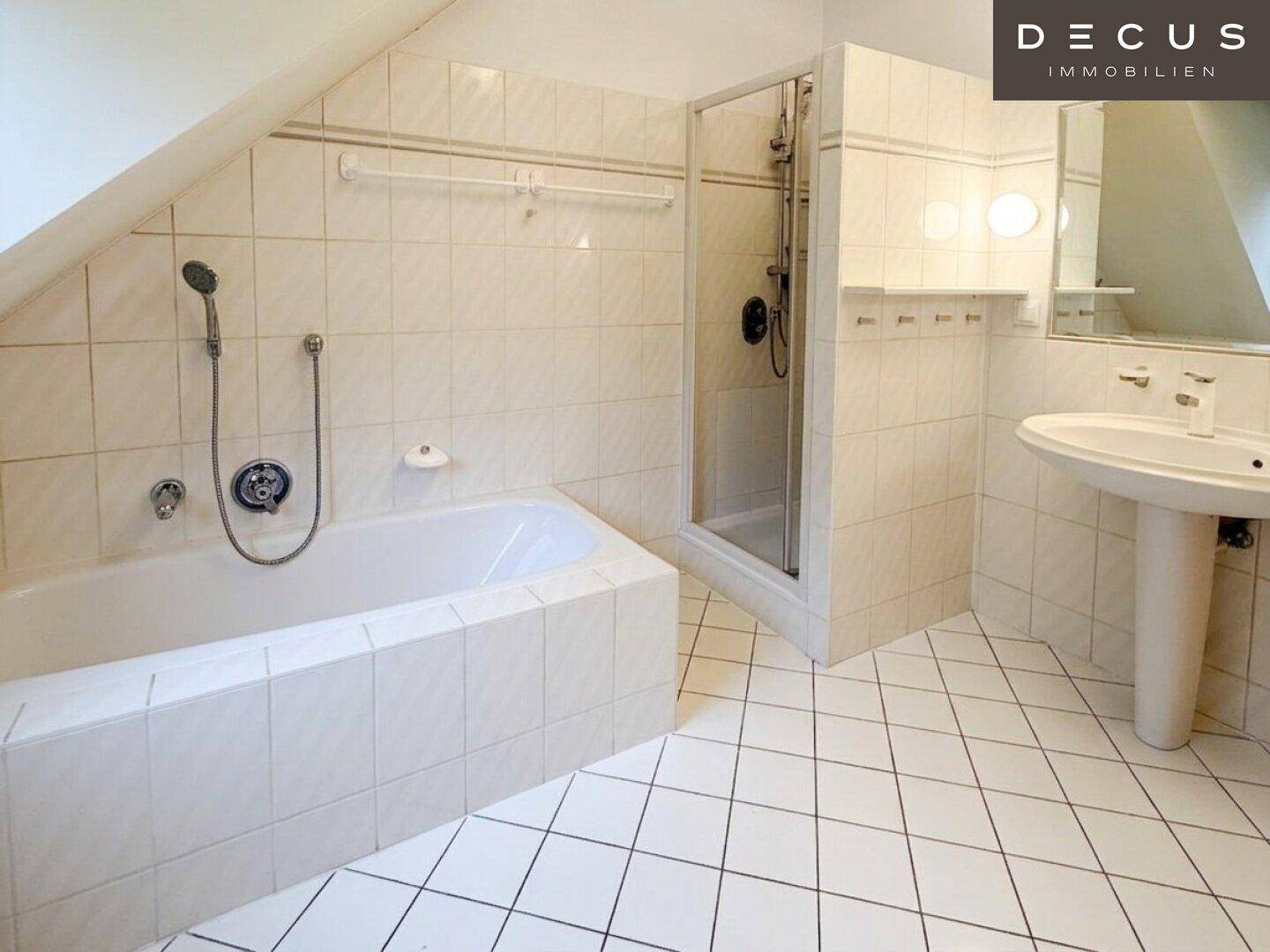 Badezimmer im Dachgeschoss mit Badewanne, Duschkabine und Waschtisch.