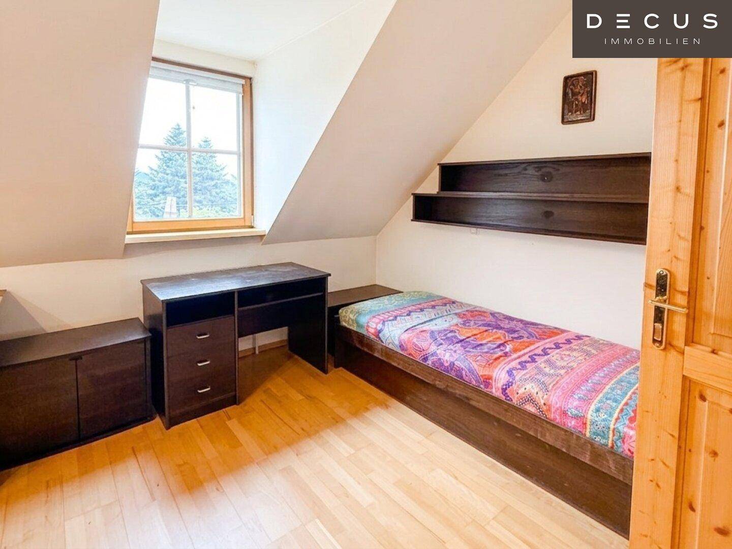 Kinder- oder Gästezimmer im Dachgeschoss mit Einzelbett, Schreibtisch und Fenster.
