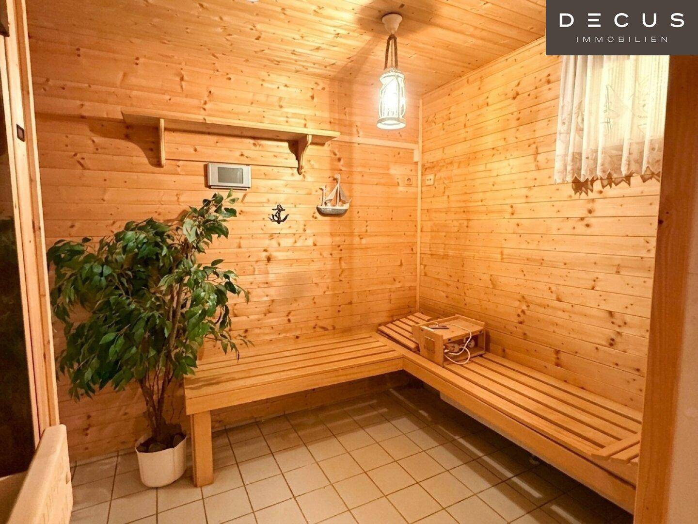 Geräumige Holzsauna mit Bänken und stimmungsvoller Beleuchtung für Wellnessmomente.