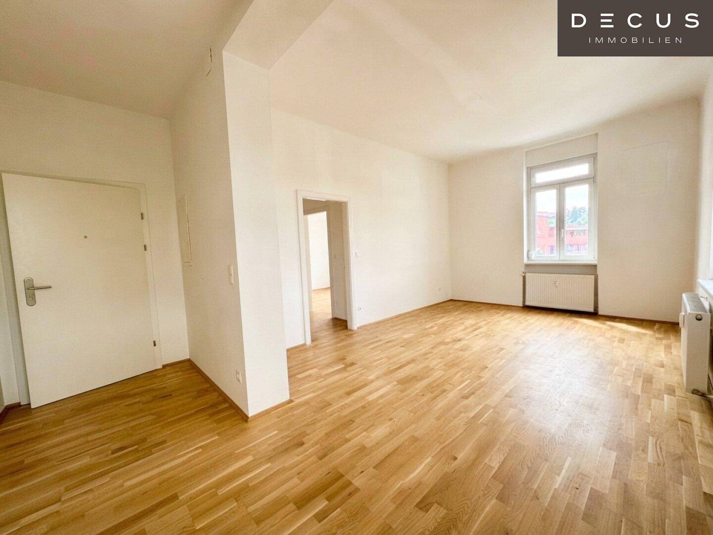 Heller Wohnraum mit Holzboden, großen Fenstern und viel Tageslicht, ideal für gemütliche Stunden.