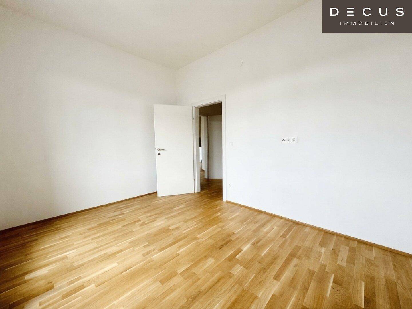 Geräumiges Zimmer mit Holzboden und weiß gestrichenen Wänden, bietet vielseitige Nutzungsmöglichkeiten.