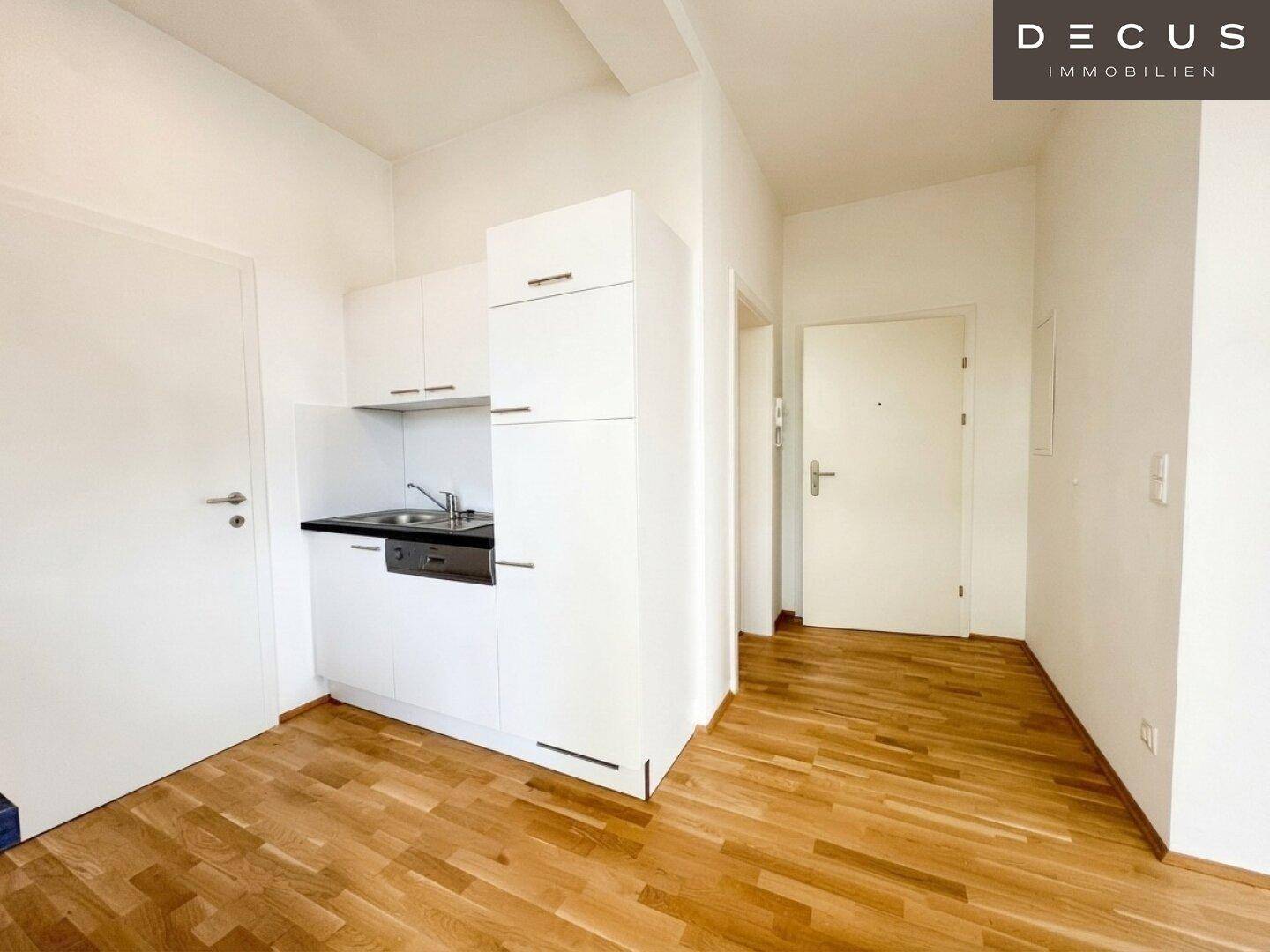 Kompakte Küchenzeile in einem hellen Raum mit Holzboden, ideal für ein Studio-Apartment.