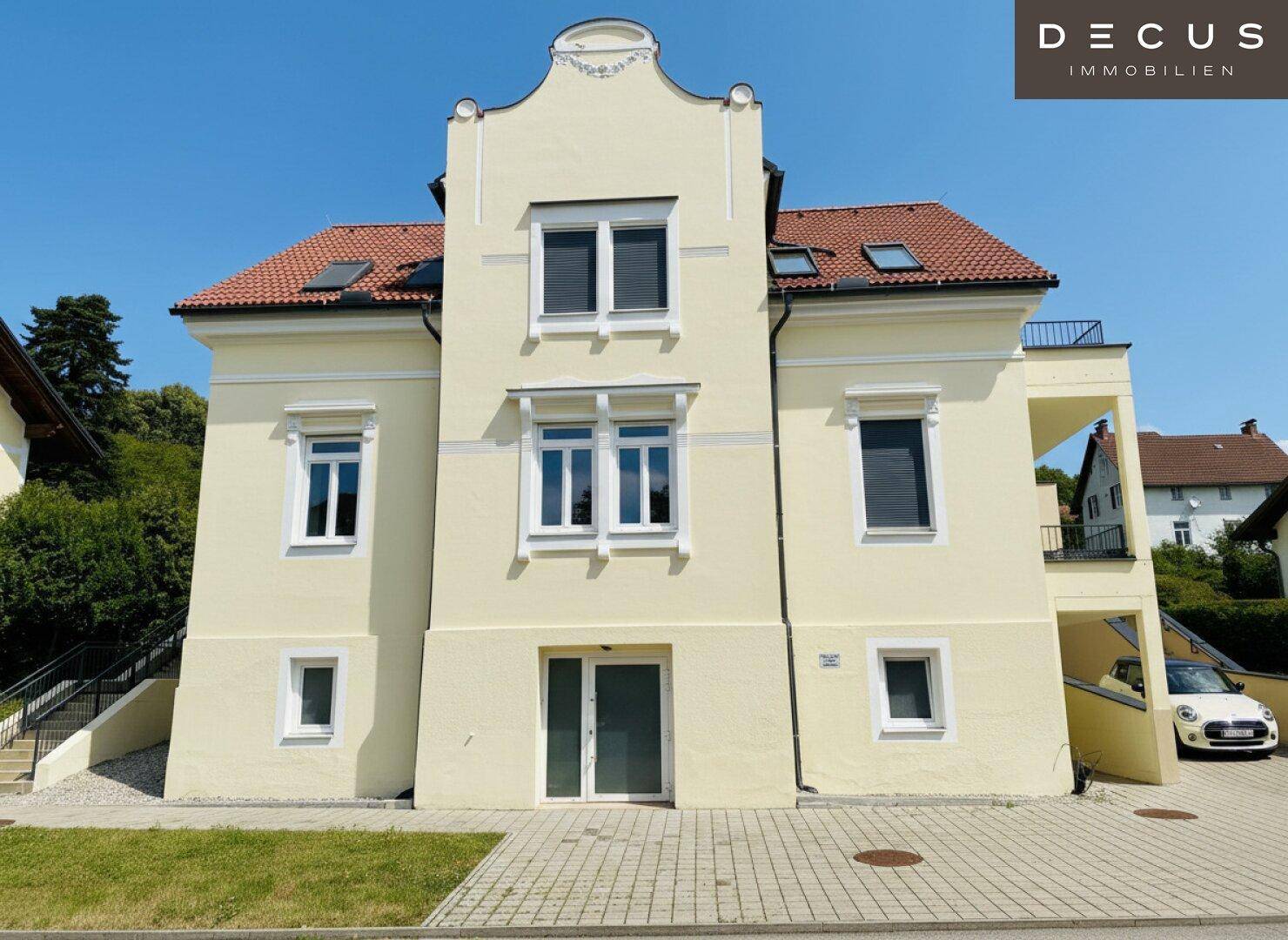 Attraktive Fassade eines Mehrfamilienhauses in hellem Gelb mit klassischer Architektur.