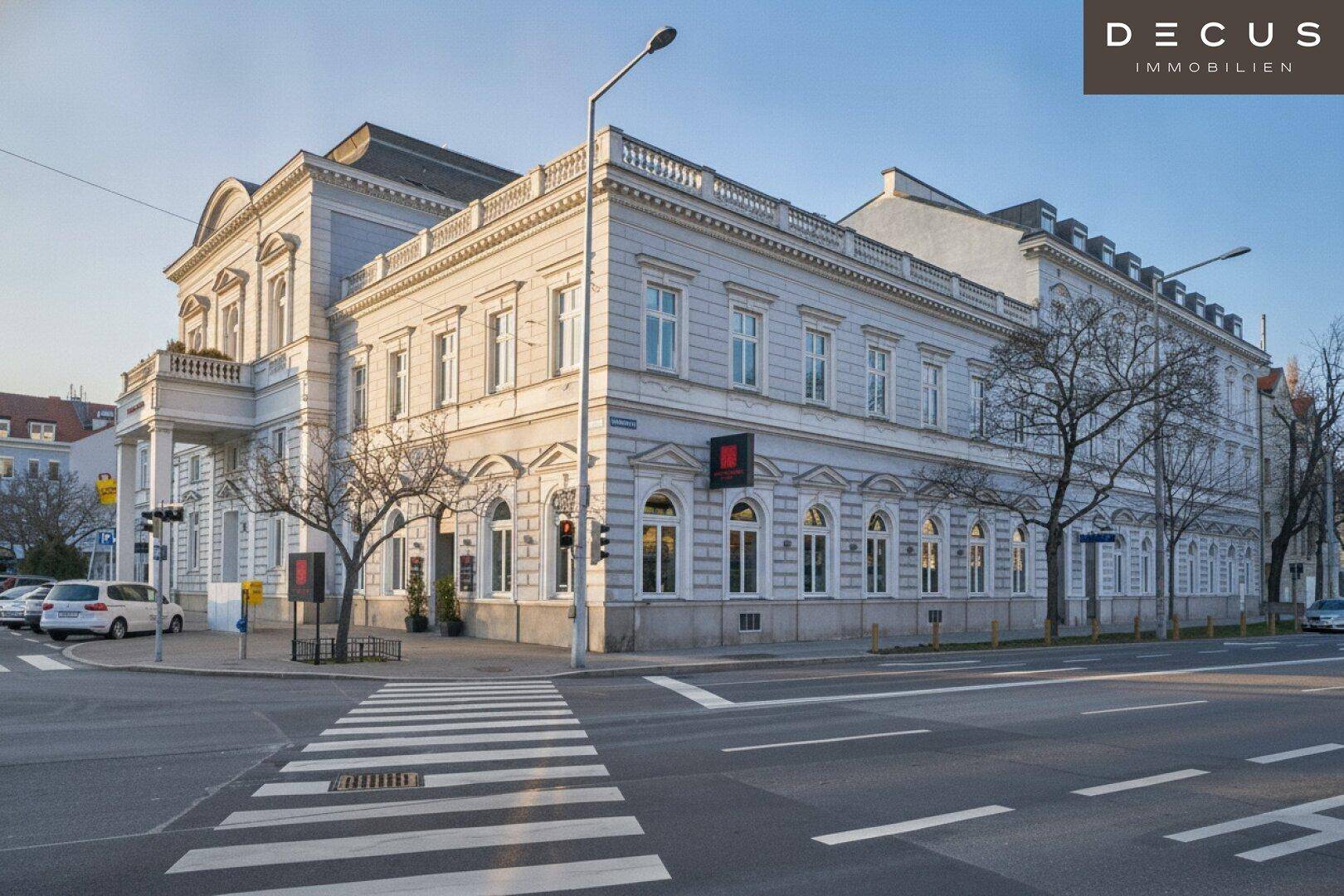 Prächtiges klassisches Gebäude an einer Straßenecke mit historischer Architektur und vielen Fenstern.