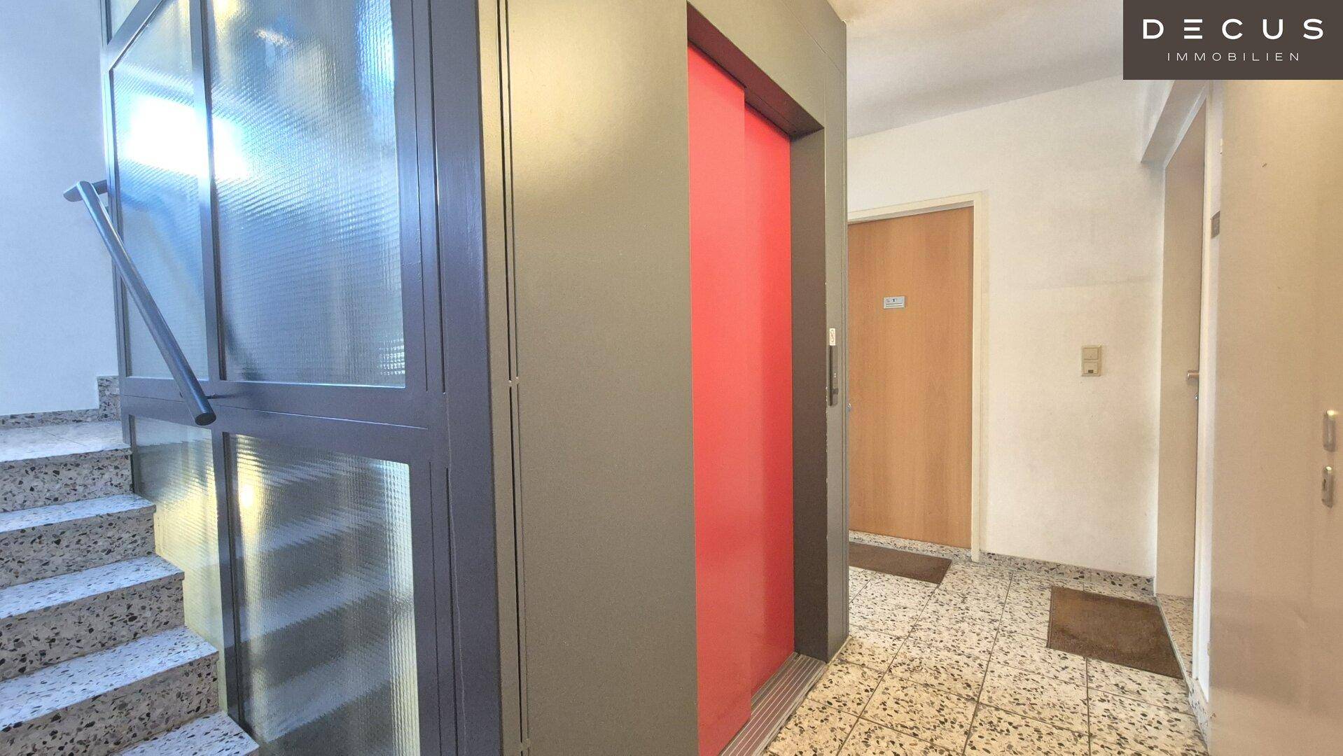 Gemeinschaftlicher Flur mit Aufzug und Treppenhaus, ausgestattet mit Fliesenboden.
