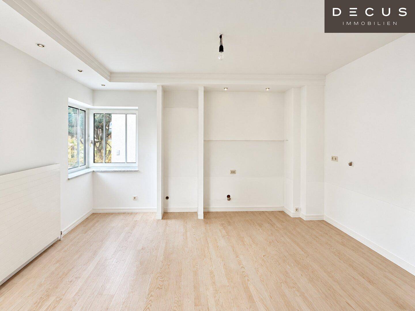 Geräumiger, heller Raum mit Laminatboden, Einbaunischen und indirekter Deckenbeleuchtung.