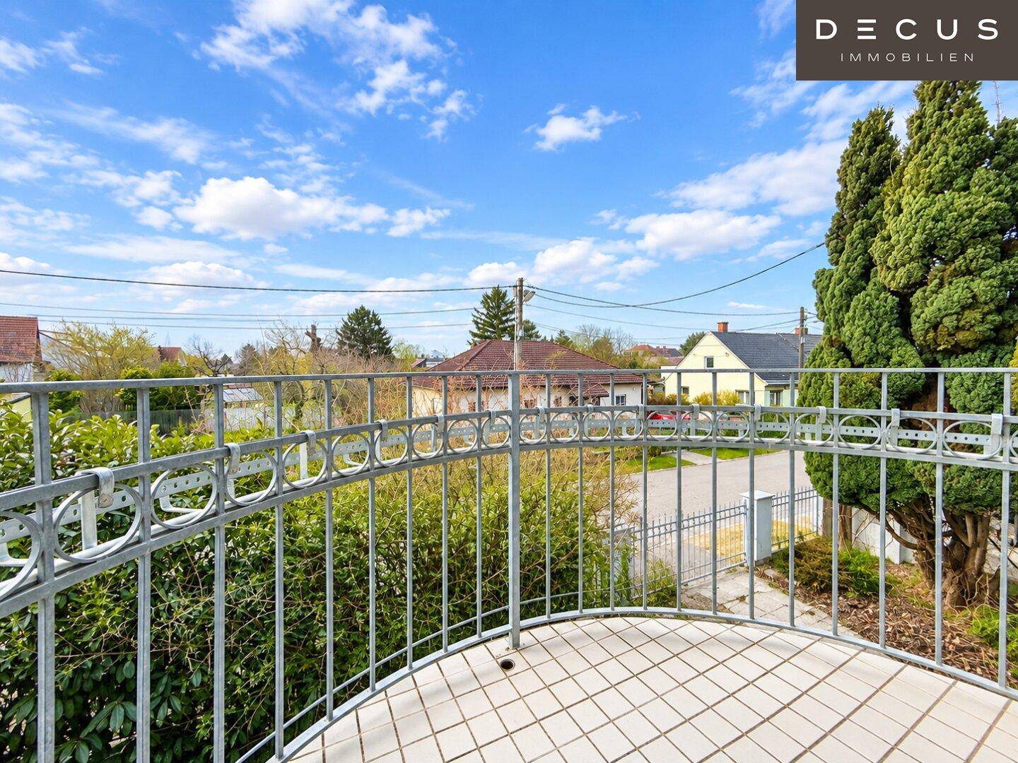 Kleiner Balkon mit Metallgeländer und Blick auf die umliegende Wohngegend.