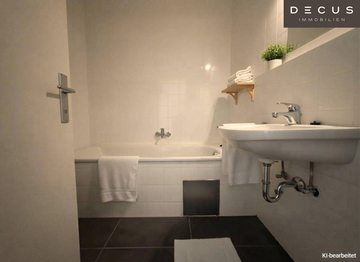 Funktionales Badezimmer mit Badewanne, Waschbecken und weißen Fliesen an den Wänden.