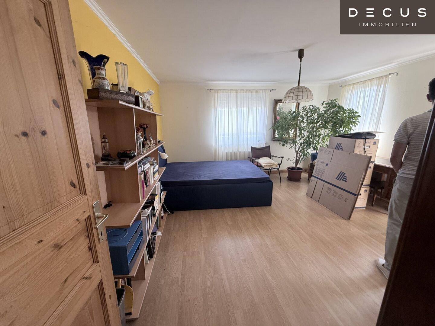 Geräumiges Schlafzimmer mit Laminatboden und viel Tageslicht, bietet Platz für individuelle Einrichtung.
