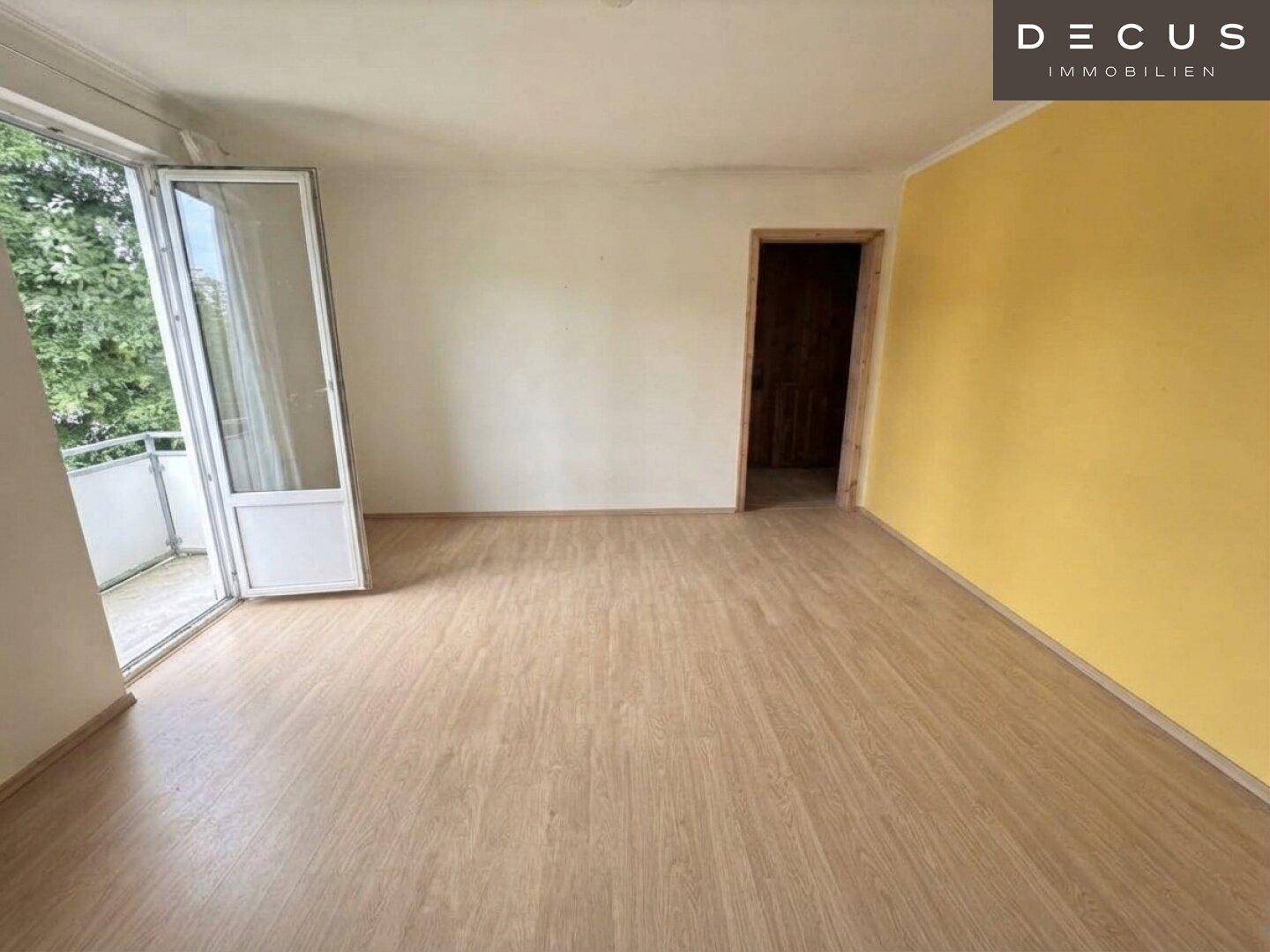 Helles Zimmer mit Laminatboden und Zugang zu einem Balkon, ideal als Schlaf- oder Arbeitszimmer.