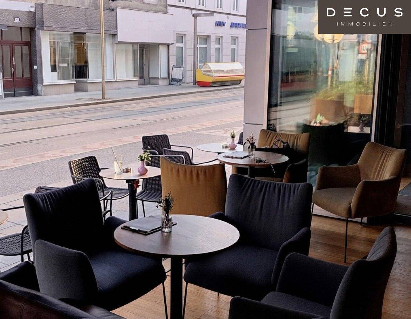 Außenbereich mit Tischen und Stühlen auf dem Bürgersteig, ideal für Gäste mit Blick auf die Straße.