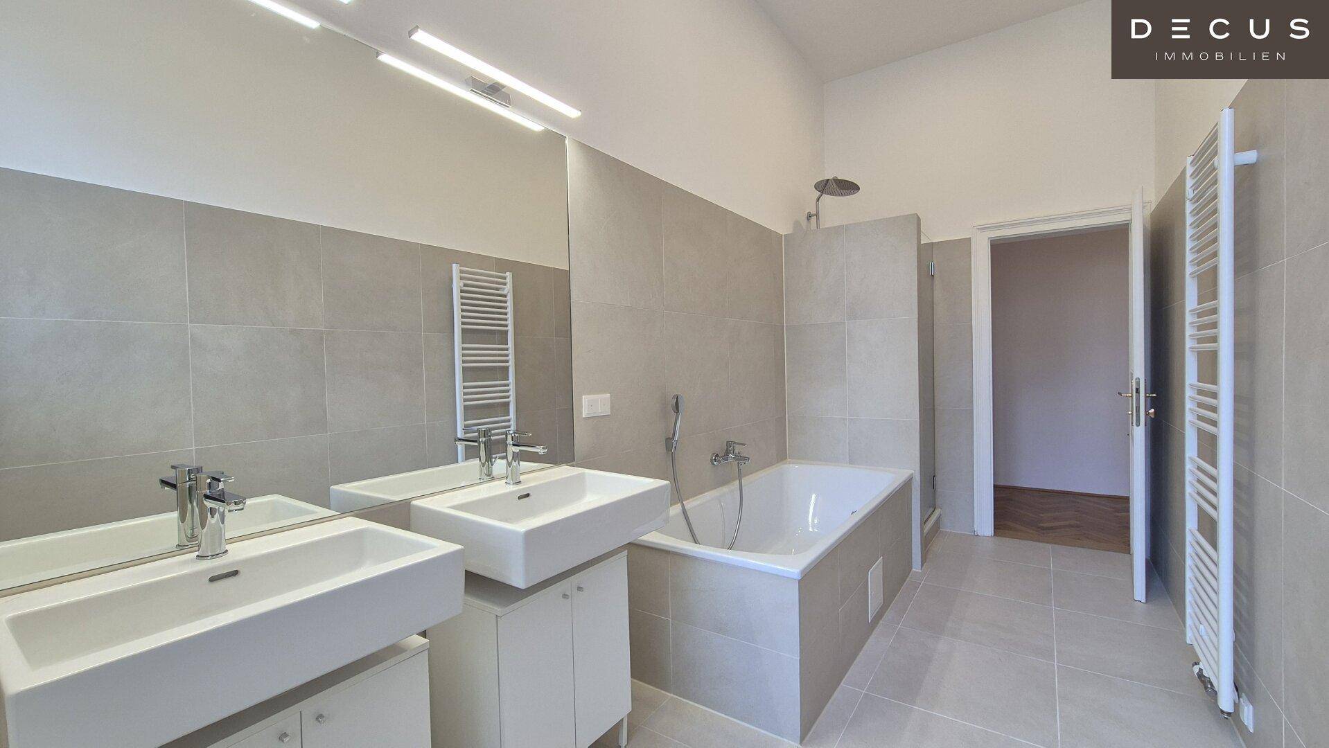 Elegantes Badezimmer mit zwei Waschbecken, Badewanne und separater Dusche.