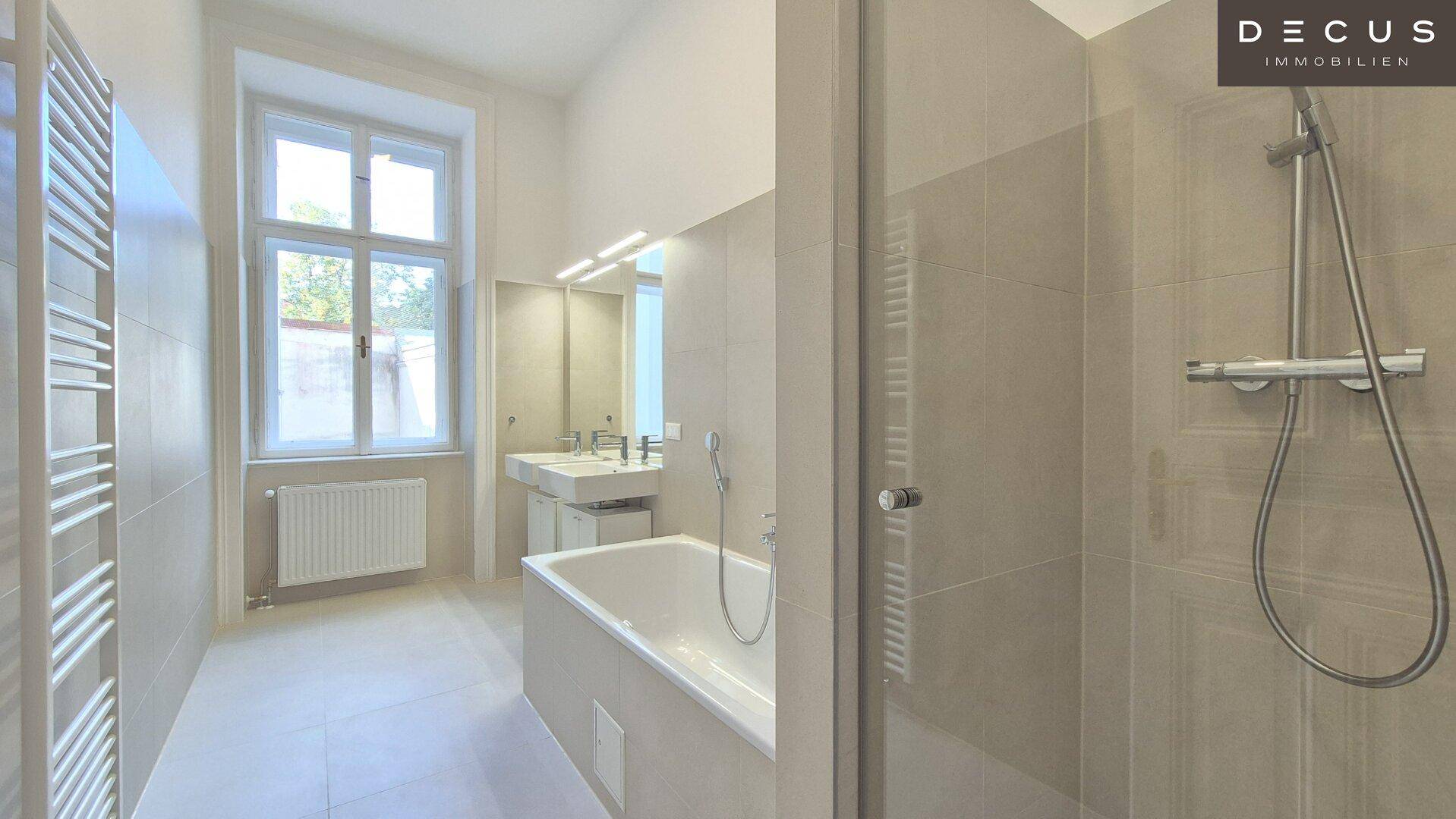 Modernes Badezimmer mit Badewanne, Dusche, Doppelwaschbecken und beheiztem Handtuchhalter.
