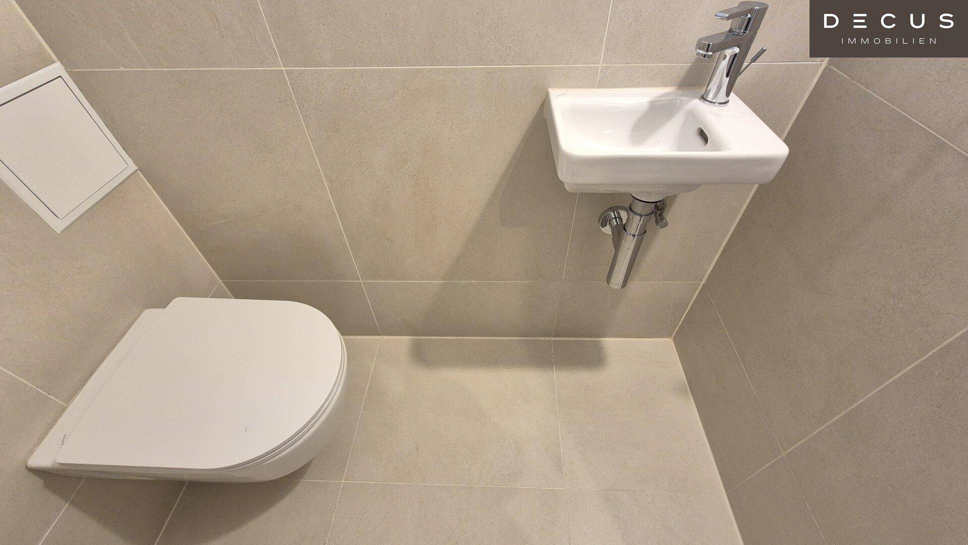 Modernes Gäste-WC mit Wand-WC und kleinem Handwaschbecken.