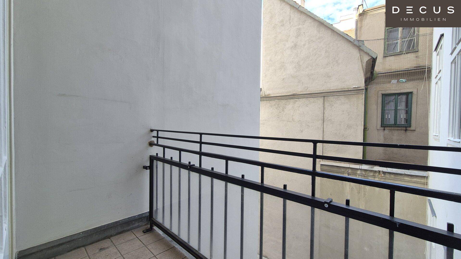 Kleiner Balkon mit Metallgeländer und Blick auf die umliegenden Gebäude.