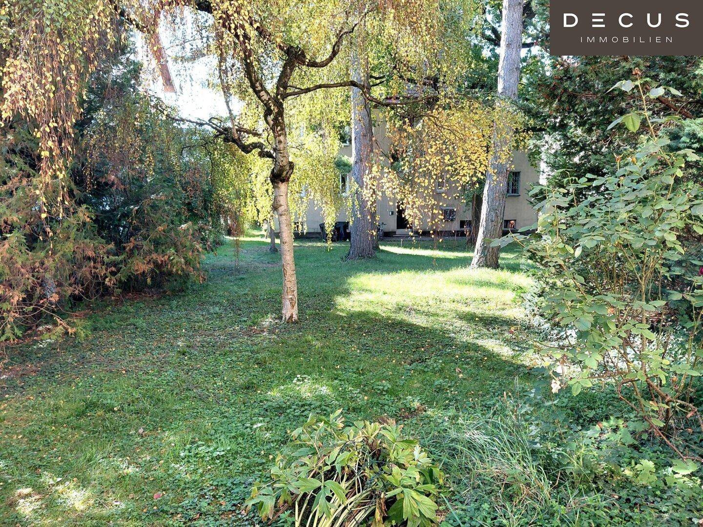 Weitläufiger Gartenbereich mit vielen Bäumen und Rasenflächen, ideal zum Entspannen.