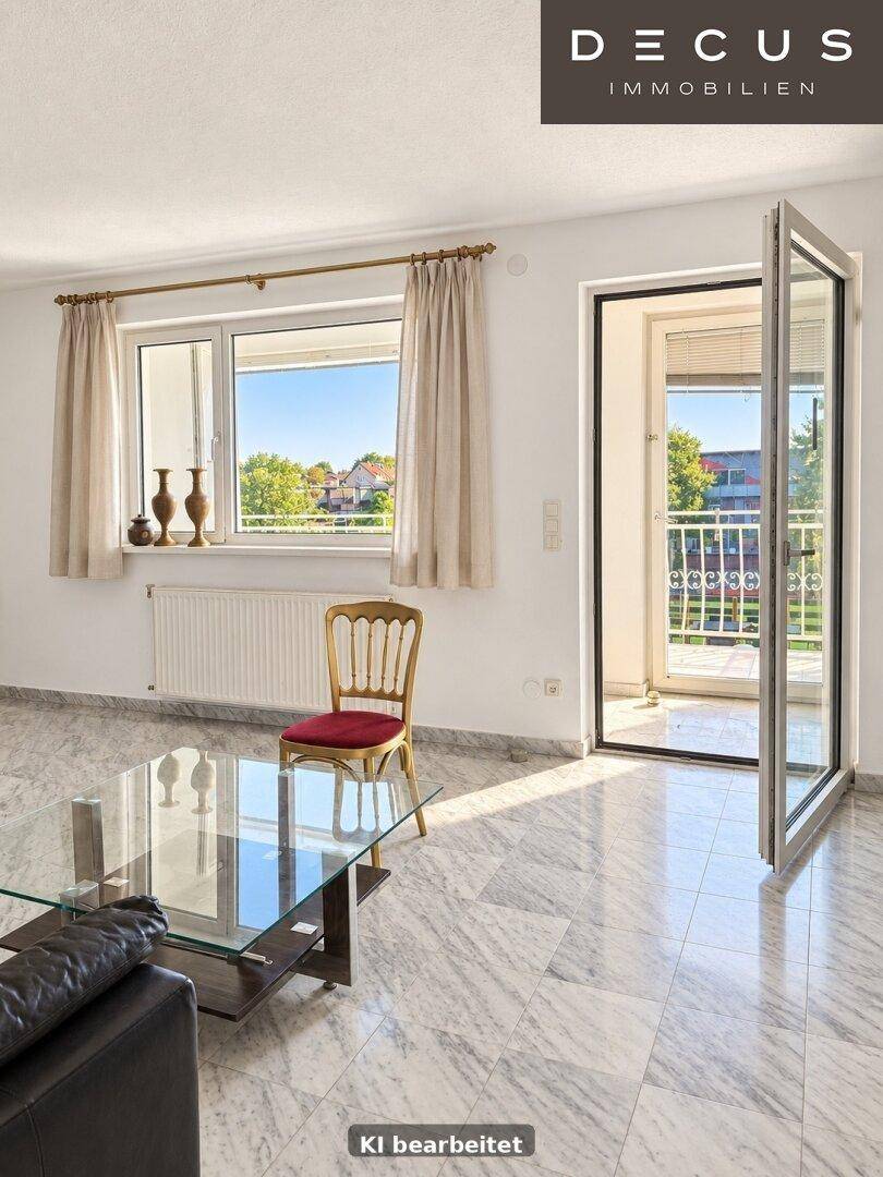 Lichtdurchfluteter Wohnbereich mit großen Fenstern und französischem Balkon.