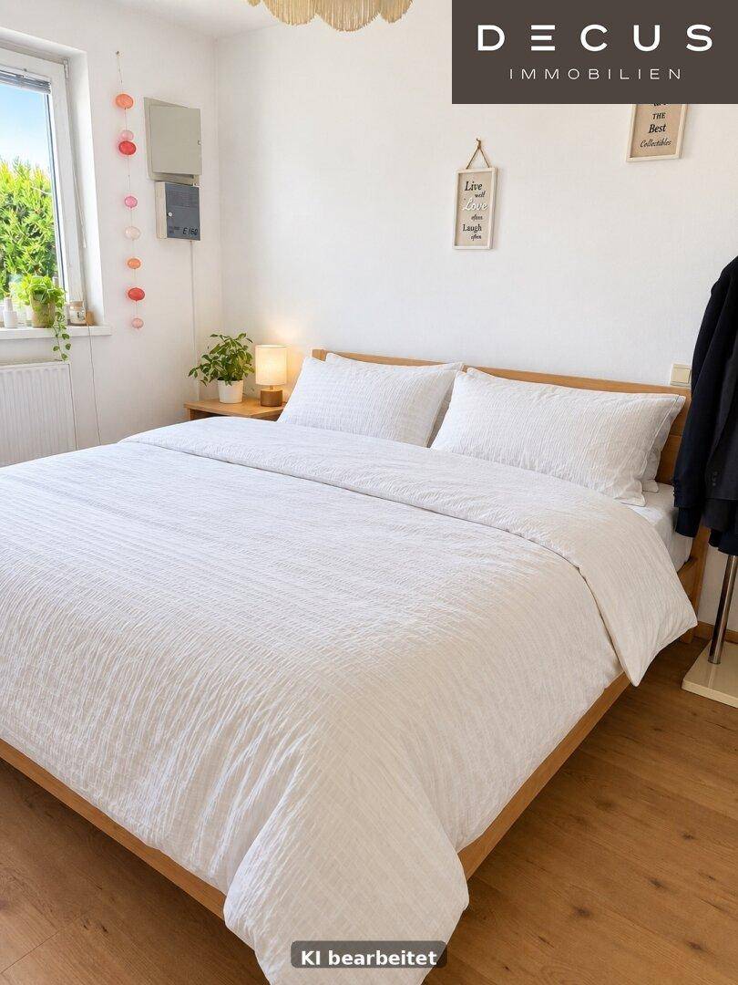 Gemütliches Schlafzimmer mit hellem Holzboden, weißer Bettwäsche und Fensterblick ins Grüne.