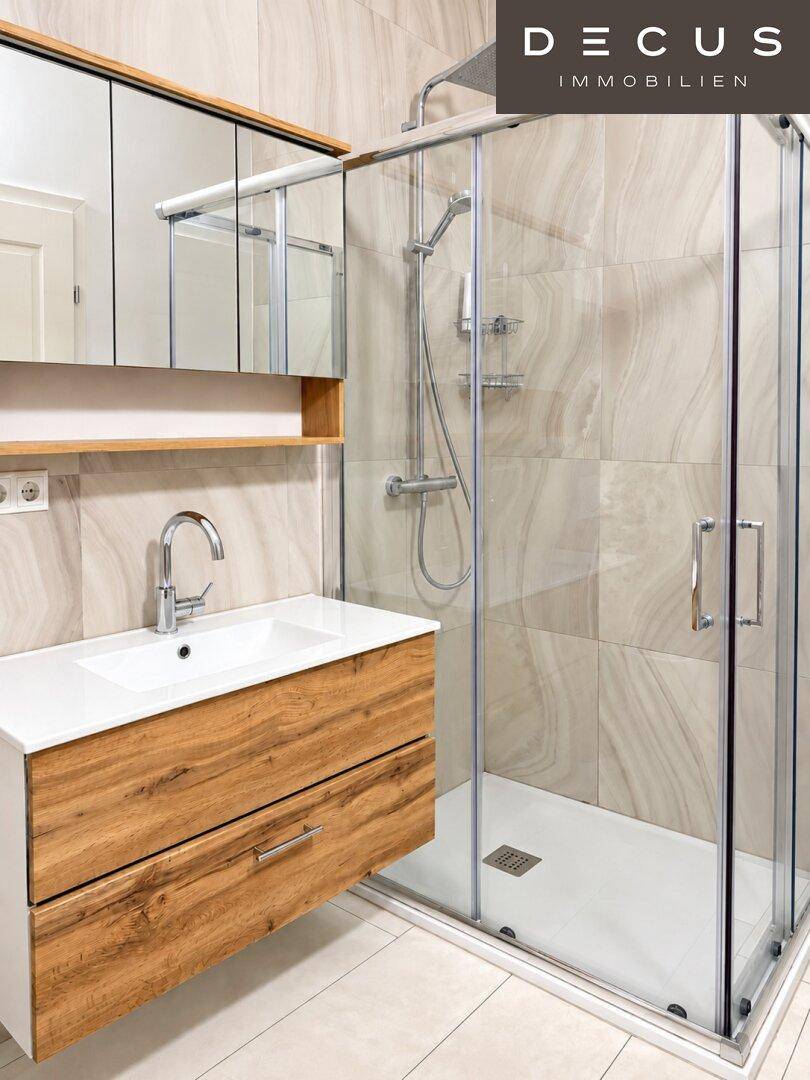 Modernes Badezimmer mit begehbarer Dusche, Holzwaschtisch und Spiegelschrank.