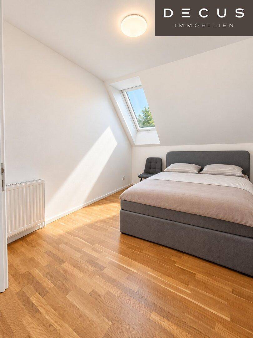 Gemütliches Schlafzimmer mit Holzboden, Dachfenster und viel natürlichem Lichteinfall.