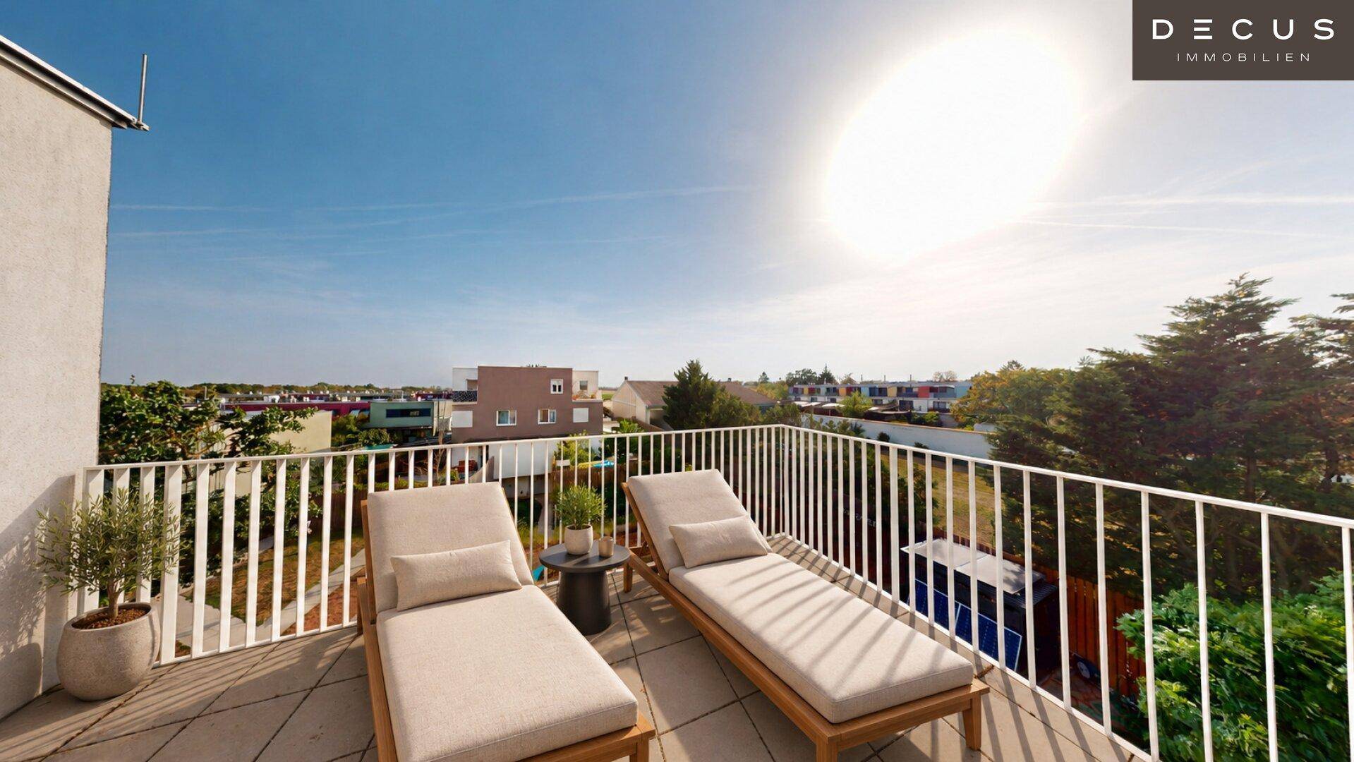 Sonniger Balkon mit bequemen Liegestühlen und weitem Blick über die Umgebung.