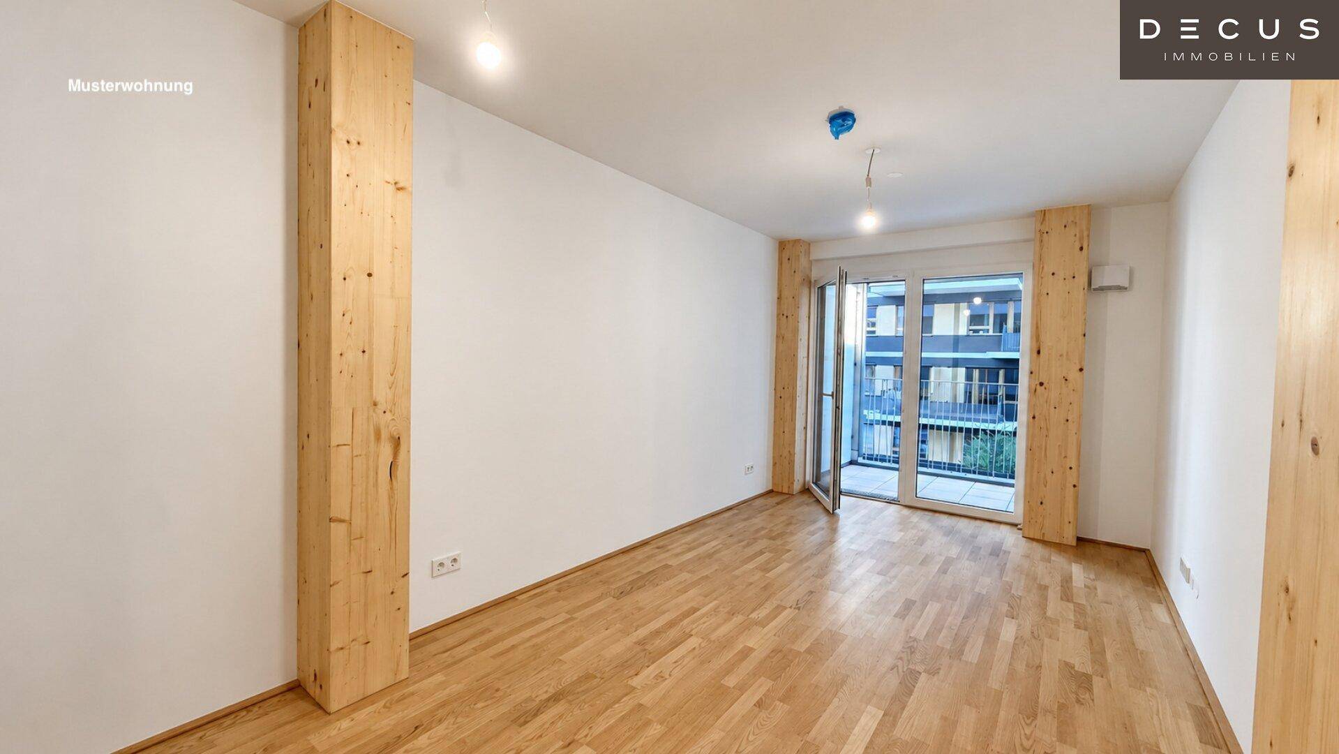 Heller Raum mit Holzboden und Zugang zu einem Balkon, mit viel Tageslicht.