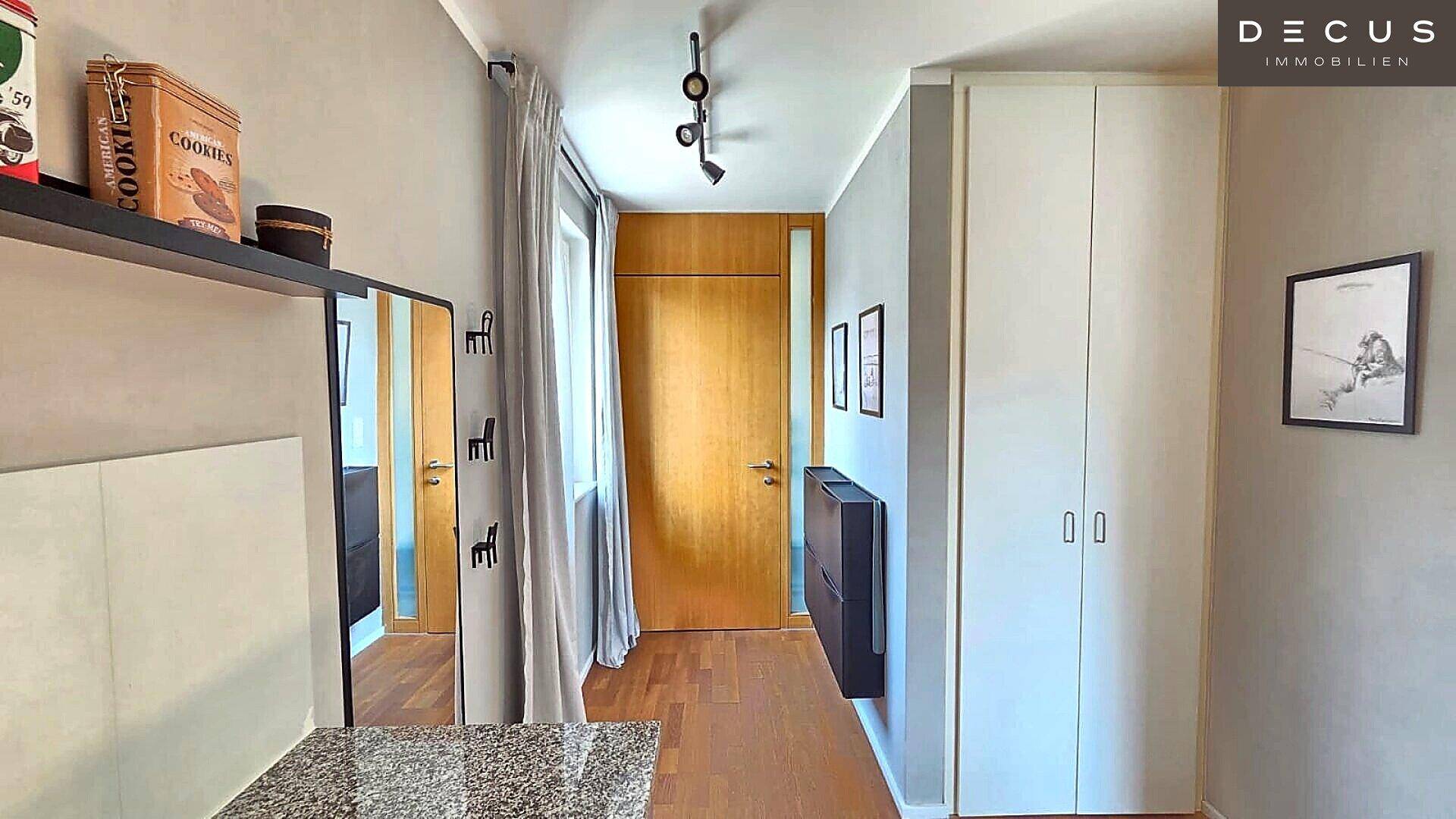 Heller Eingangsbereich mit Garderobe, Spiegelschrank und Holzboden.