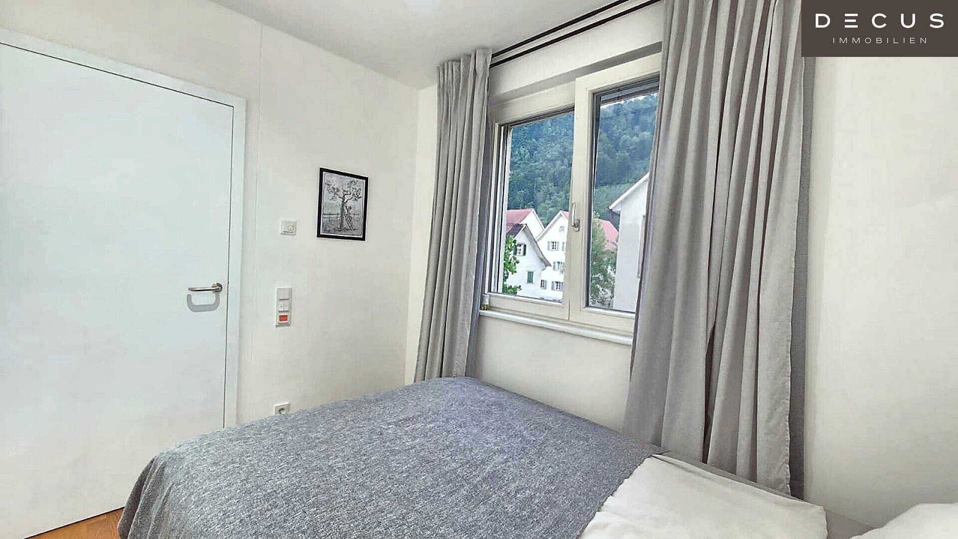 Gemütliches Schlafzimmer mit Einzelbett, Fenster und Blick ins Grüne.