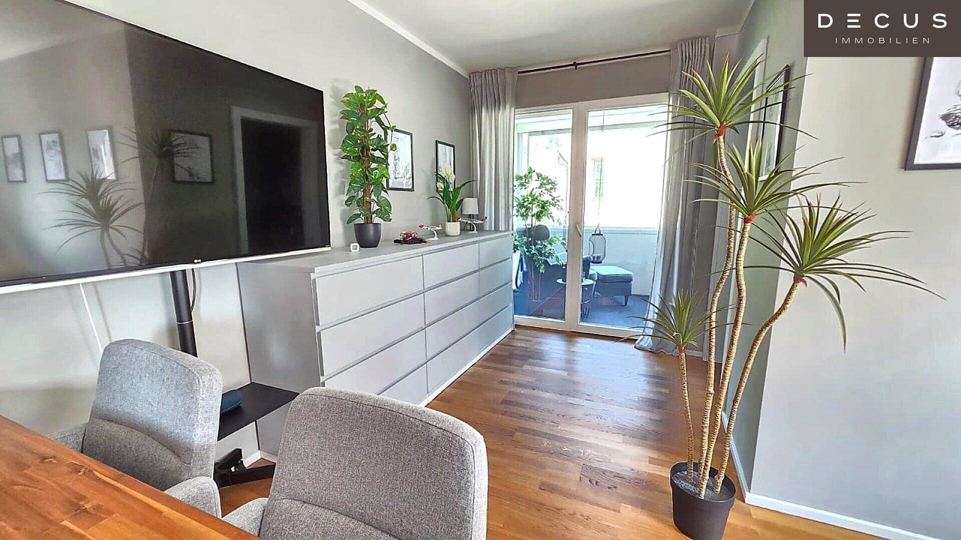 Heller Wohnbereich mit Holzboden und direktem Zugang zur Loggia.