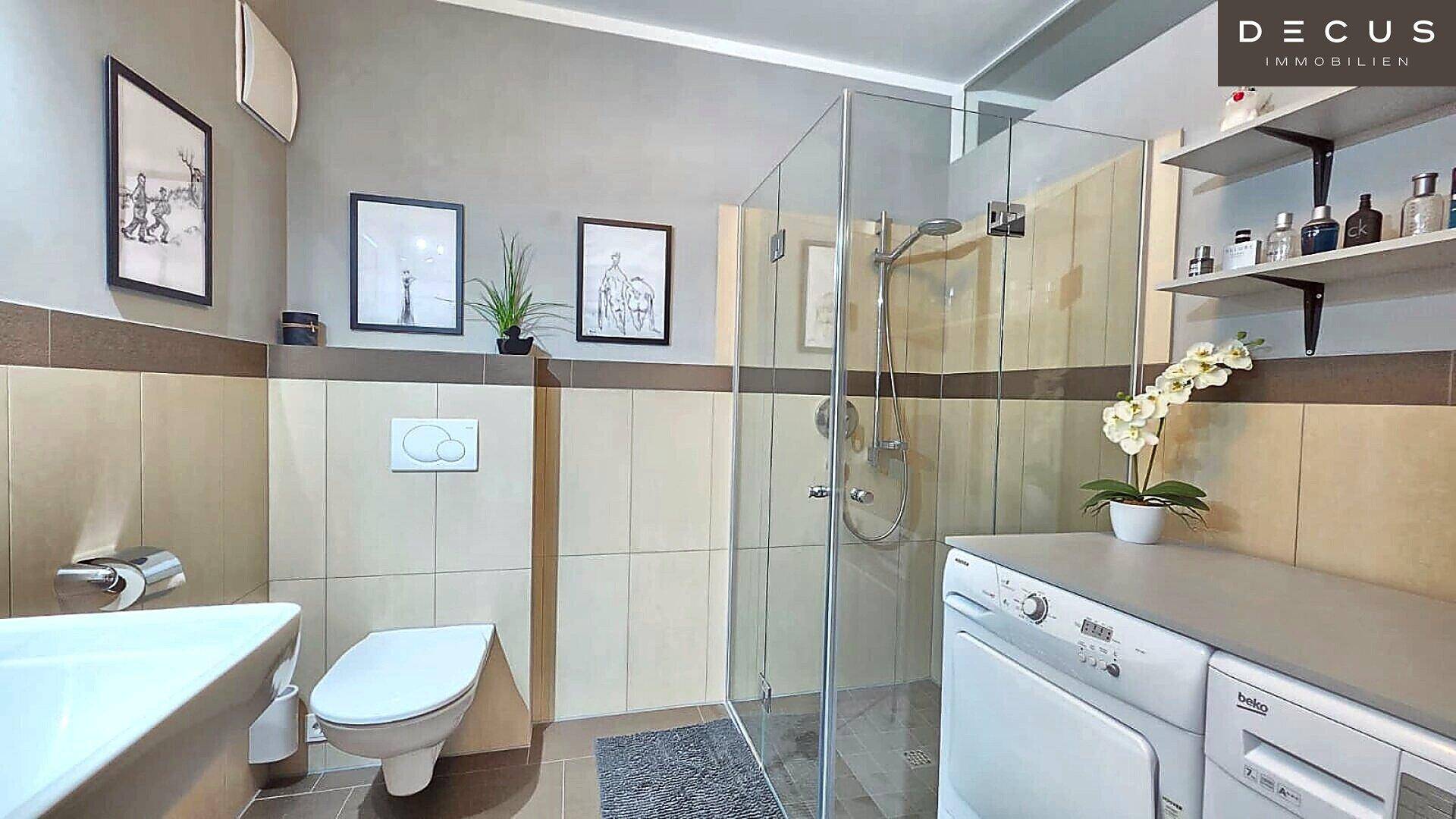 Helles Badezimmer mit großer Dusche, Waschmaschine und Trockner.