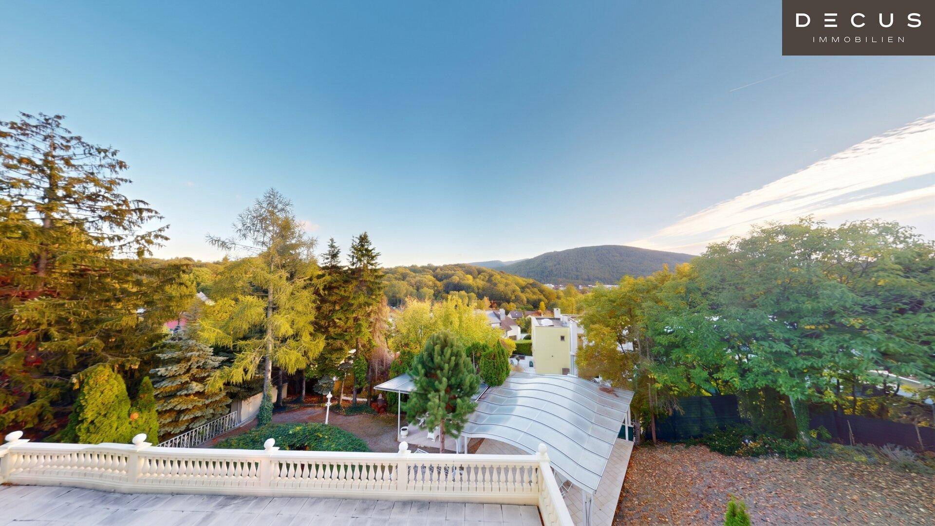 Weitläufige Terrasse mit Balustrade und Panoramablick auf die grüne Hügellandschaft.