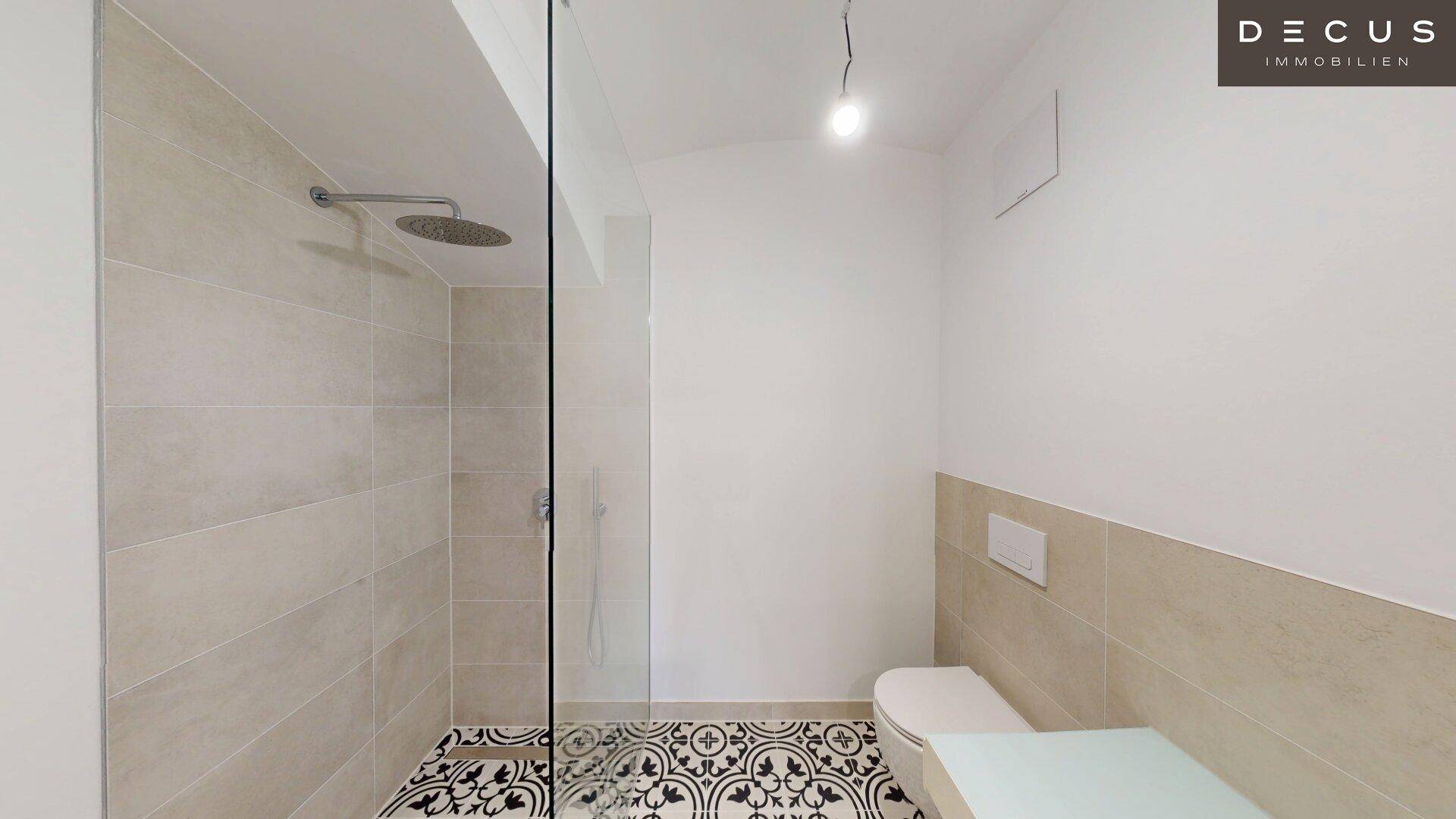 Modernes Badezimmer mit ebenerdiger Dusche, Wand-WC und dekorativen Bodenfliesen.