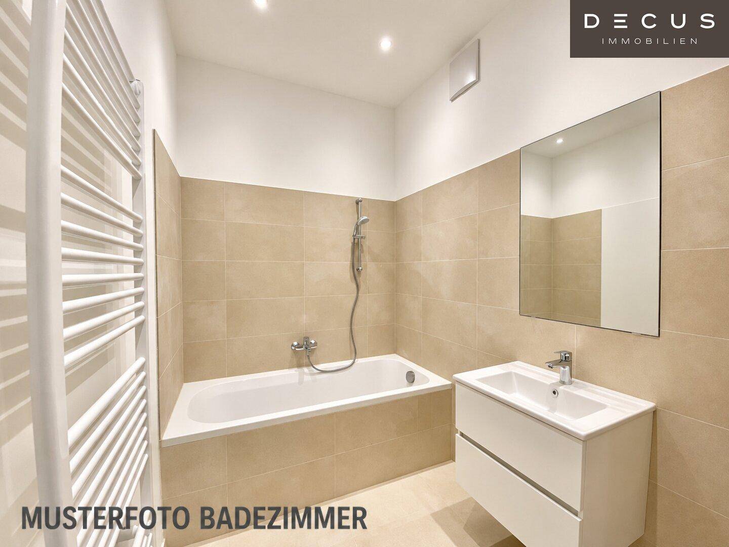 Modernes Badezimmer mit Badewanne, beheiztem Handtuchhalter und beigefarbenen Fliesen.