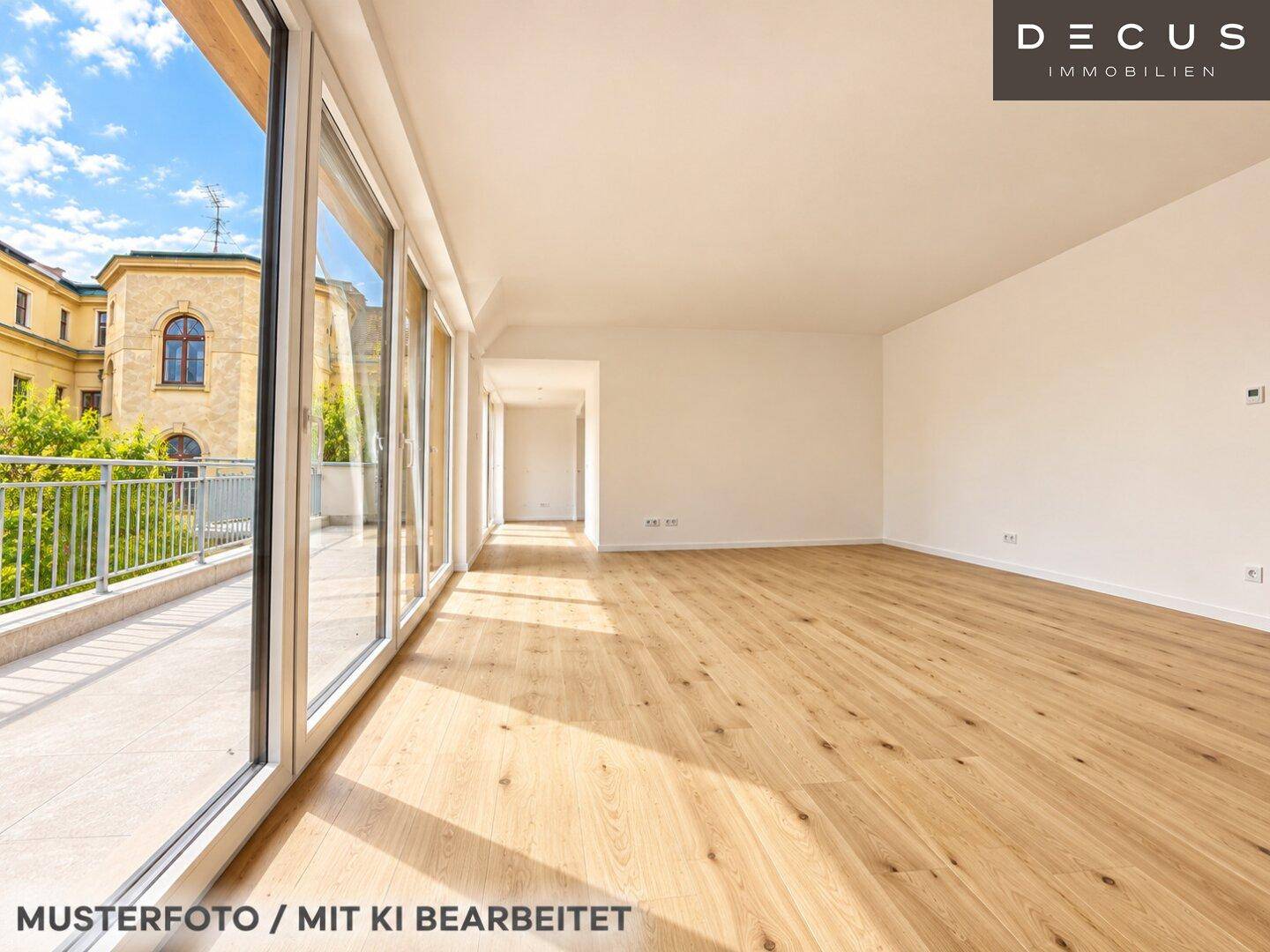 Heller, leerer Wohnbereich mit großen Fenstern, Holzboden und Zugang zur Terrasse.