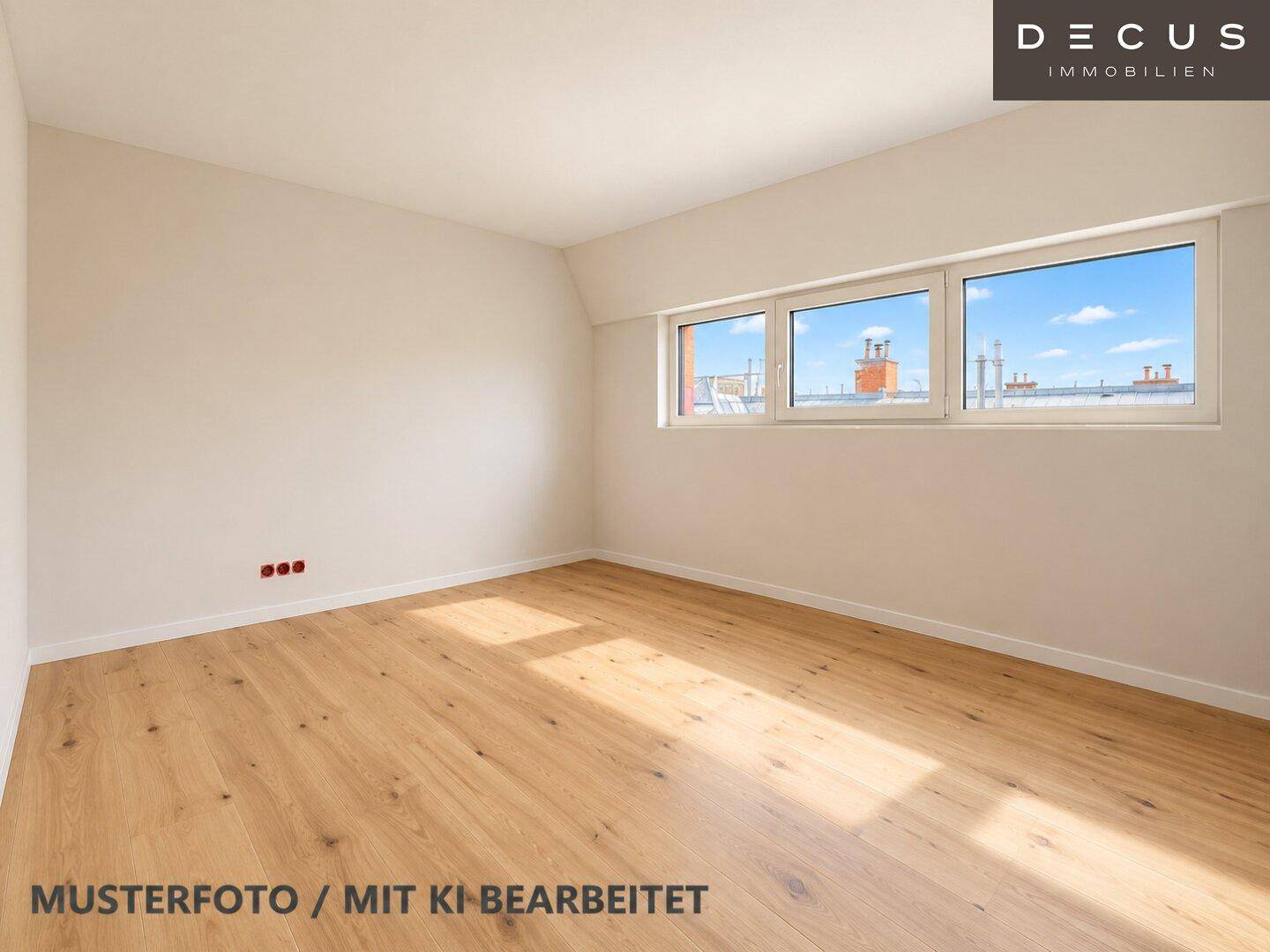 Helles, unmöbliertes Zimmer mit Holzboden und Blick auf die umliegenden Dächer.