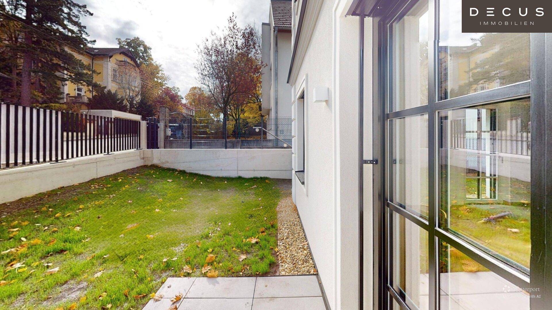 Kleiner, gepflegter Gartenbereich mit Rasenfläche neben dem Gebäude.