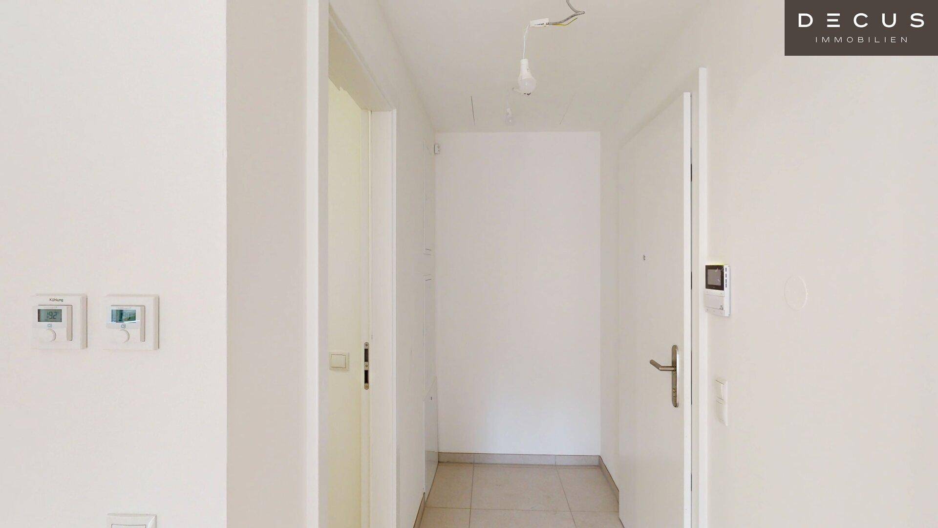 Heller Eingangsbereich mit Fliesenboden und Zugang zu verschiedenen Zimmern der Wohnung.