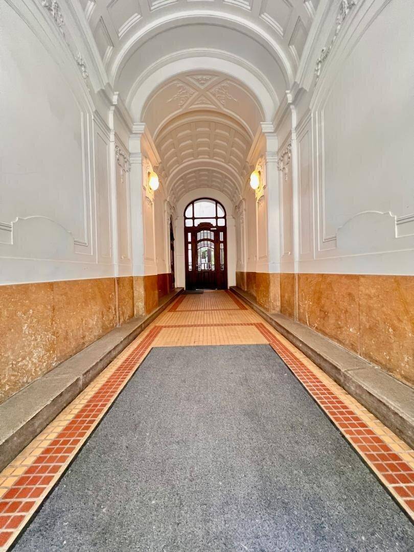 Eleganter Eingangsbereich mit gewölbter Decke, Stuckverzierungen und traditionellem Fliesenboden.