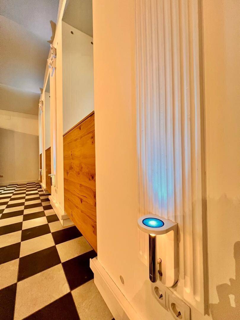 Detailaufnahme einer Wand mit dekorativer Säulenverzierung und integrierter blauer LED-Beleuchtung.