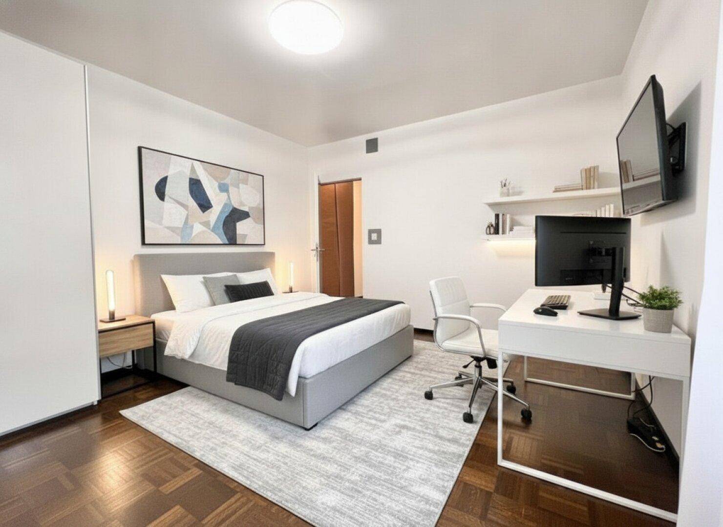 Modernes Schlafzimmer mit integriertem Arbeitsbereich, Parkettboden und großem Fenster.