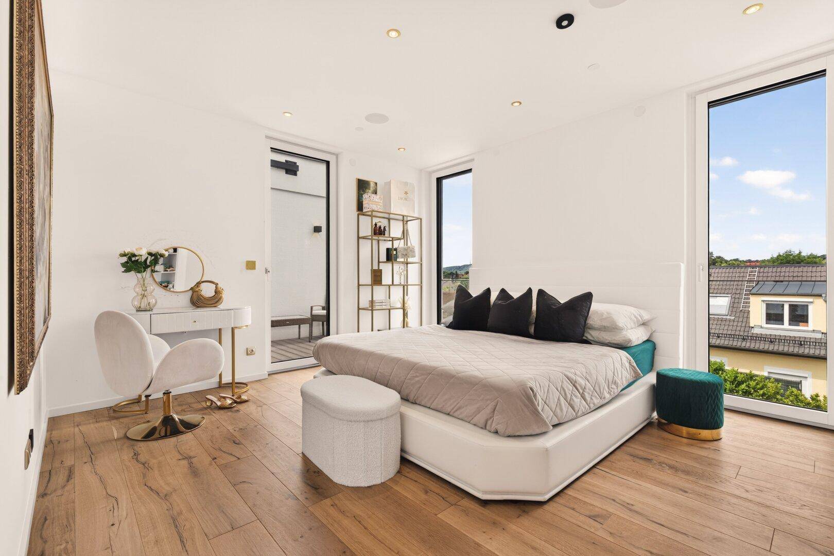 Elegantes Schlafzimmer mit Holzboden, weißem Bett und stilvoller Dekoration.