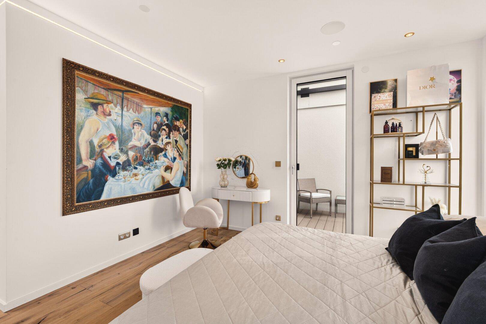 Schlafzimmer mit Holzboden, großem Kunstwerk und Zugang zu einem privaten Außenbereich.