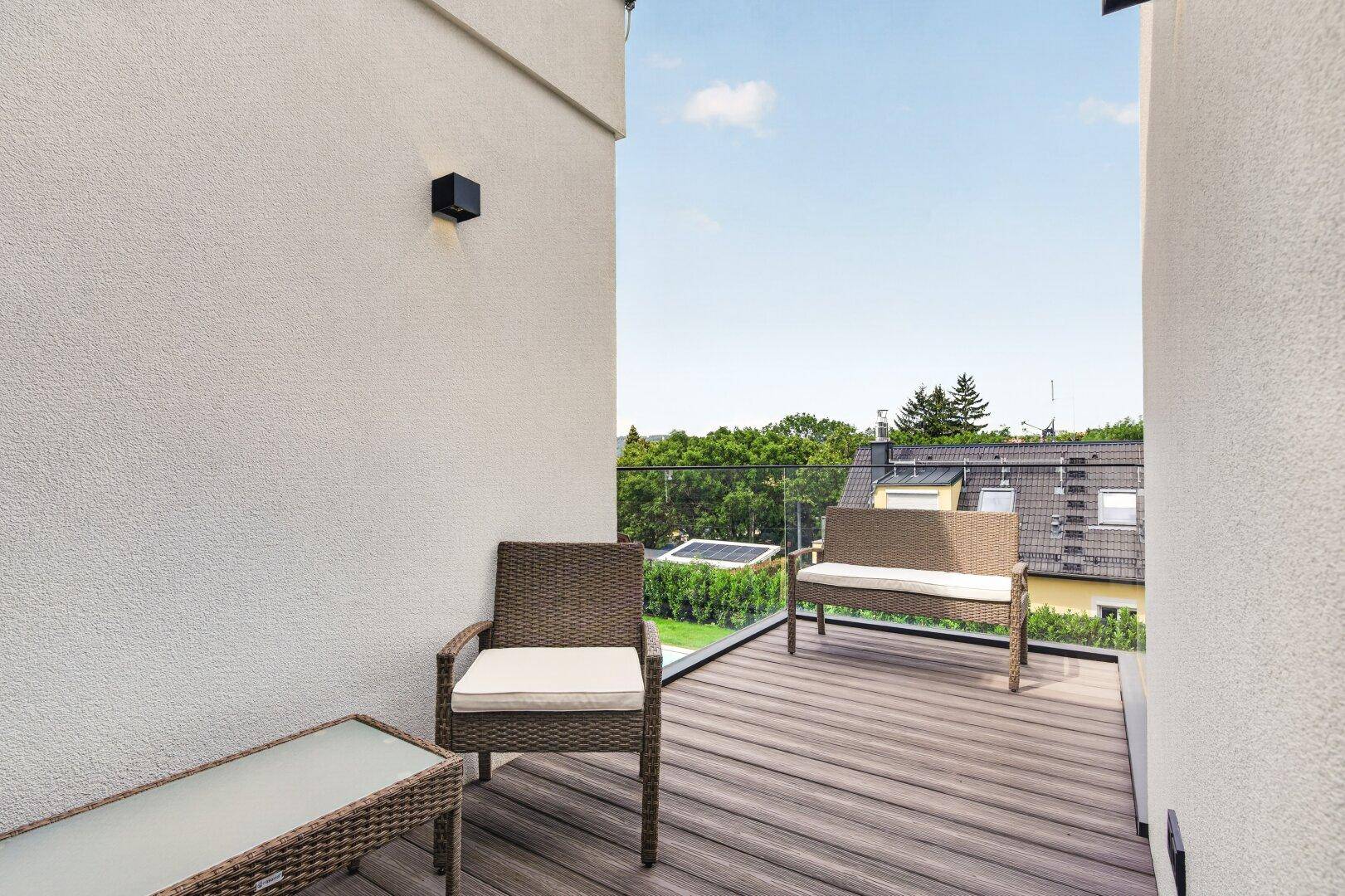 Gemütliche Terrasse mit Rattanmöbeln und Blick auf die umliegende Wohngegend.
