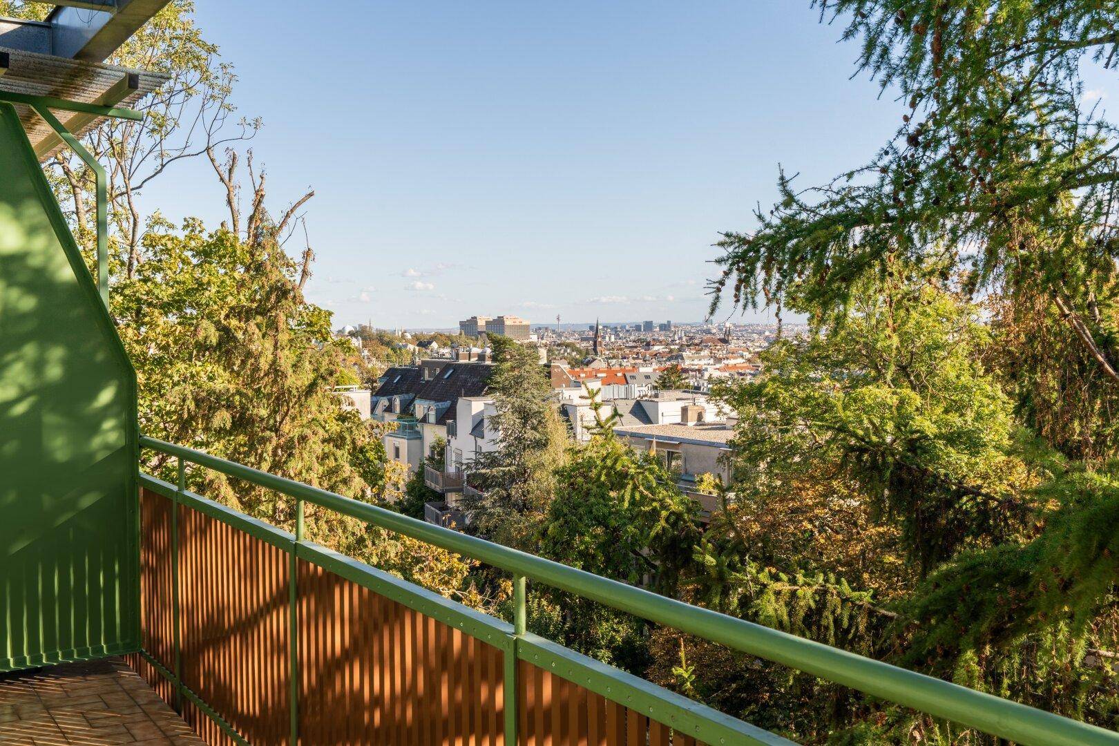 Langer Balkon mit Stadtblick, umgeben von Bäumen und viel Grün, ideal zum Entspannen.